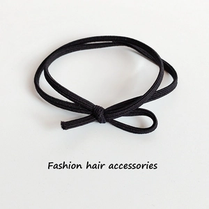 Elastic black double-strand hair tie with minimalist bow knot on white background