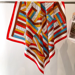 Detailed view of colorful twisted pattern silk scarf with elegant red borders and texture