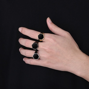 Polished hexagonal signet rings for men in gold, black, and silver finishes on hands