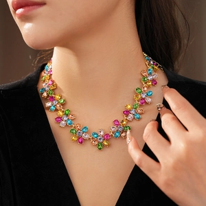 Close-up of model wearing colorful crystal flower necklace in vintage gold finish