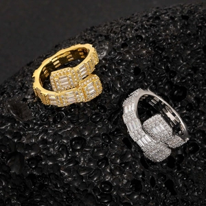 Vista macro di anelli hip hop in oro e argento con zirconi su una pietra vulcanica scura