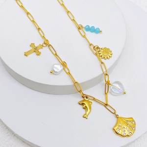 Ocean theme gold necklace with shell dolphin pendants and blue beads on a display