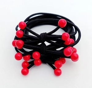 Detail of black elastic hair bands with glossy red sphere beads and hand-knotted design