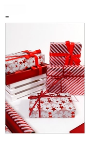 Detail of red Christmas gift wrapping paper with star patterns and satin ribbons