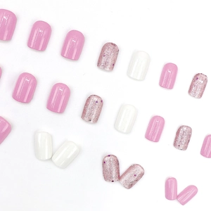 Short pink and white press-on nails with glitter accents and glossy finish for women