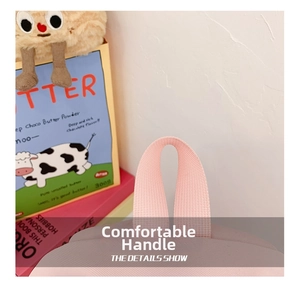 Close-up of the comfortable pink handle on the backpack with a plush toy background
