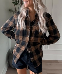 Detailed view of plaid shirt texture featuring breast pocket and button-down closure