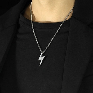 Collier pour homme avec pendentif éclair en acier argenté porté par un mannequin chic