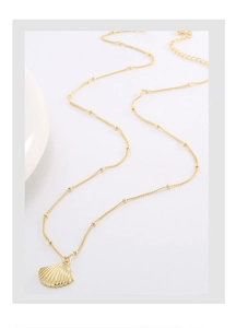 Detailed shot of a gold shell pendant necklace with a fine beaded chain on white background