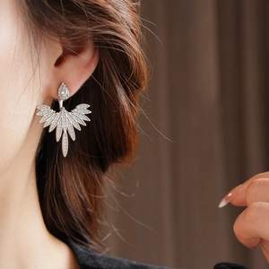 Detailed view of silver zircon leaf-shaped earrings worn by a model in close-up