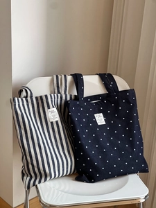 Détail de sacs cabas en denim vintage avec motifs à rayures et pois sur une chaise