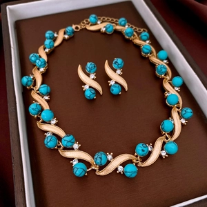Close-up of vintage jewelry set with turquoise beads and crystals in a display box