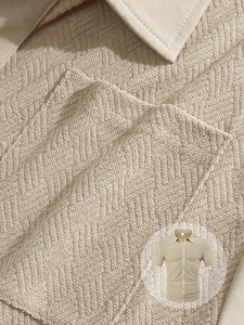 Detailed macro view of beige waffle textured fabric and stitching on men's lapel shirt