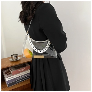 Close-up of transparent PVC shoulder bag with white chunky chain and gold hardware