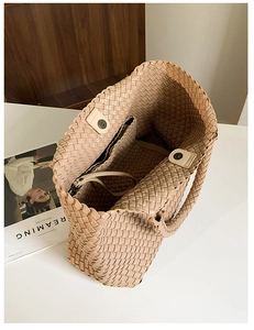 Detail view of woven tote bag showing magnetic buckle closure and internal pocket