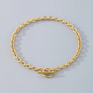 Gold stainless steel link bracelet featuring a stylish OT buckle on a gray background