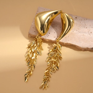 Detail shot of golden fringe earrings with irregular petal shape and mirror finish