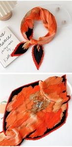 Detail of pleated silk scarf with orange floral pattern and black accents in two layouts