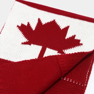 Close-up of the knitted scarf showing a red maple leaf pattern and fine woven texture