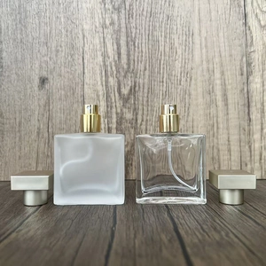 Detailed comparison of frosted and clear square glass perfume bottles with gold spray caps