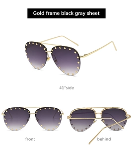 Detail view of gold metal half-frame sunglasses with rivet accents and gradient lenses