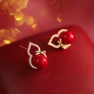 Elegant gold gourd stud earrings with red agate and zircon bow on red leather base