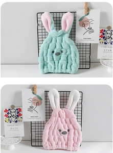 Close-up of thick coral fleece fabric texture and cute rabbit ears on drying hair caps