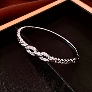 Silver linked 18K gold-plated bangle featuring crystal inlay and woven texture