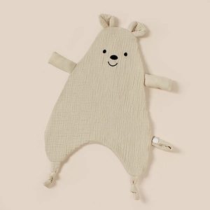 Detail showing embroidered bear head on soft beige muslin gauze baby comforter with snap tag