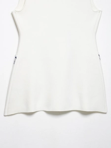 Close-up of white knitted vest hemline showing fine vertical ribbed texture and stitching