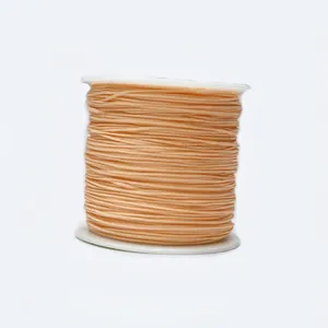Close-up of 0.8mm light orange braided cord on a spool for jewelry and DIY crafts