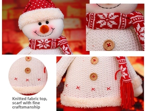 Detail of knitted snowman doll with white sweater, wooden buttons and snowflake scarf