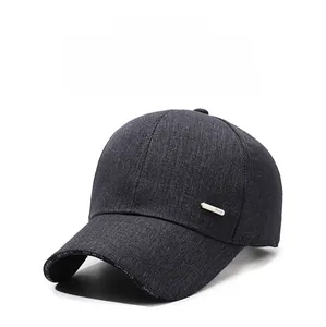 Detail view of dark gray baseball cap showing denim texture and metal decorative plate