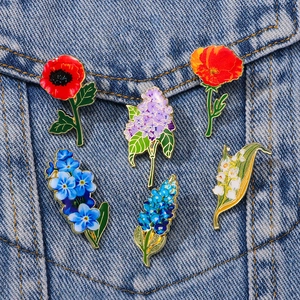 Floral enamel pins featuring lily of the valley and lilac on denim jacket pocket