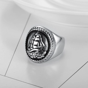 Vintage silver nautical ring with embossed sailboat and detailed rope texture on surface