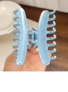 Gros plan d'une grande pince à cheveux bleu clair avec finition brillante et ressort