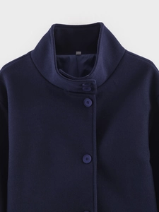 Detailed close-up of dark blue wool coat featuring a stand collar and matching buttons