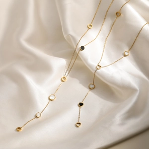 Elegant 18K gold-plated heart and circle pendant necklace on white silk fabric