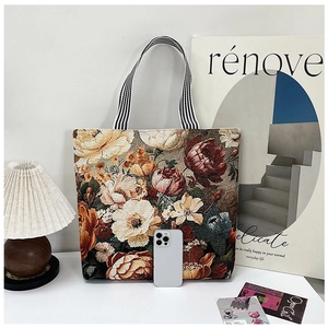 Λεπτομερής όψη vintage τσάντας tote με λουλουδάτο ζακάρ και κομψές ριγέ λαβές.
