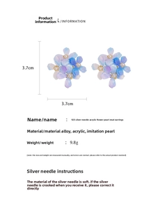 Détail de boucles d'oreilles fleur en acrylique dégradé avec perle centrale