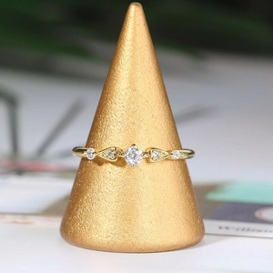 Macro shot of gold plated ring with round central zircon on a velvet stand