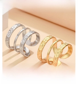 Detail of layered stainless steel rings with gold and silver finishes and hammered textures