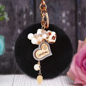 Détail du porte-clés pompon en fausse fourrure noire avec pendentif en cœur