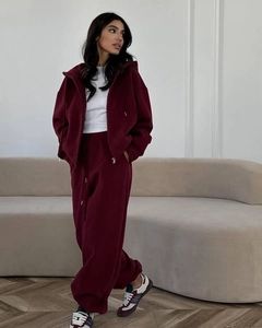 Ensemble sweat à capuche zippé bordeaux et pantalon de jogging dans un salon cosy