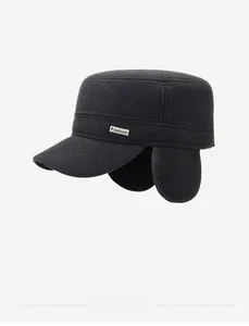Close-up of winter flat top cap featuring warm ear flaps and a metal Fashion plate