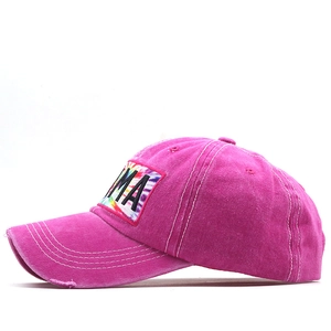 Detail of vintage rose red baseball cap with tie-dye MAMA embroidery and distressed edges