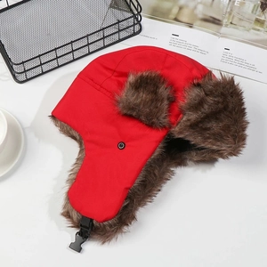 Detail view of winter red trapper hat with soft brown faux fur lining and black buckle