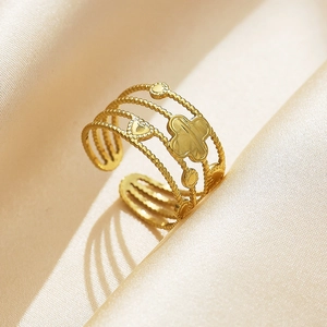 Macro shot of gold stainless steel multi-layer open ring with clover and heart motifs