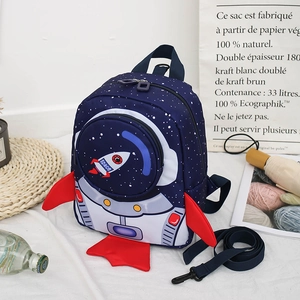 Close-up of rocket toddler backpack with safety leash on a woven mat background