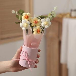 Handheld knitted flower bouquet with yellow and white crochet blossoms in pink hug bucket